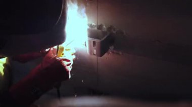 Welder works at construction site. Craftsman welds with arc welding