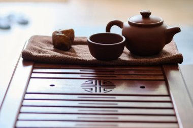 Teapot and tea cup made of yixing clay stands on a bamboo tea tray. Chinese traditional gongfu cha teaware