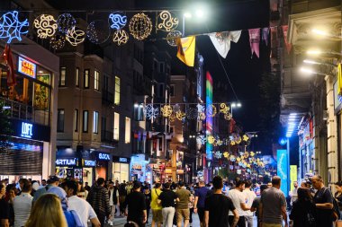 Crowds of people walking down Istiklal Caddesi in the summer night. Istanbul, Turkey - June 2022
