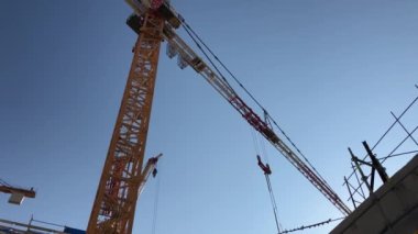 Low angle view of tower crane working at construction site