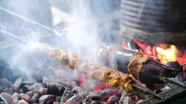 Close-up of eggplant kebab on skewers grilling on brazier. Turkish traditional kebabs grill on coal