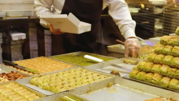 Stacks Baklava Foreground Hands Unrecognizable Seller Serves Customers Traditional Turkish — Vídeo de stock