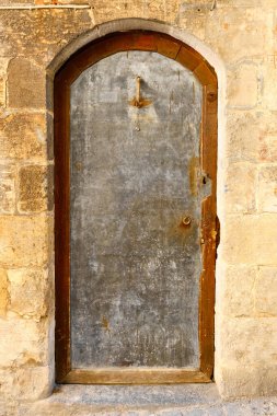 Ortadoğu evinin girişi. Taş duvarın içindeki gümüş renkli metal kapı.