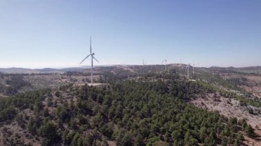 Dağ sırasının tepesindeki rüzgar enerjisi türbininin havadan görüntüsü. Rüzgar türbini çiftlik havası görüntüsü. Dağ yamacındaki rüzgar parkının panoramik manzarası