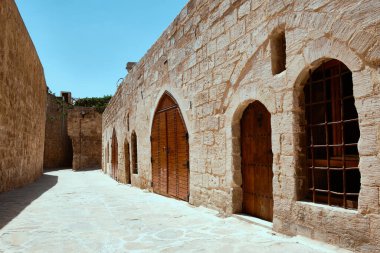 Geleneksel Ortadoğu taş evinin giriş kapısı. Orta Doğu şehrinin bir caddesinde demirden yapılmış ahşap bir kapı. Mardin sokakları, Türkiye