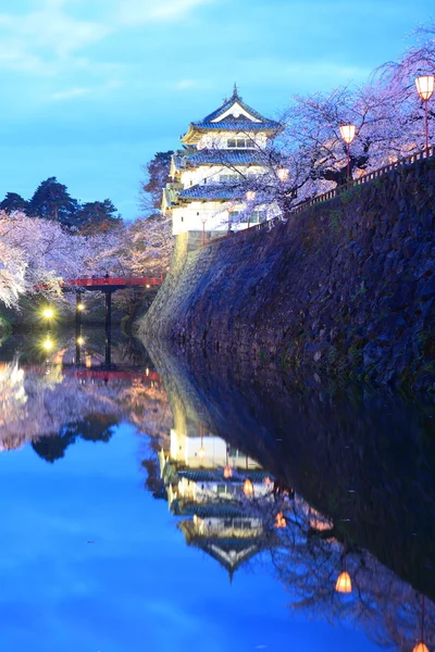 Iluminación del castillo de Hirosaki y flores de cerezo — Foto de Stock