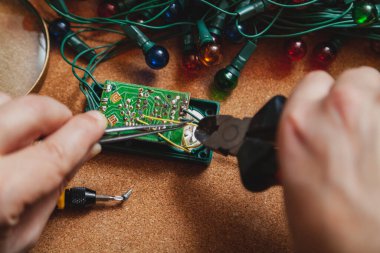 Yeni yıla hazırlanıyorduk. Köknar ağacı elektrik çelengi tamiri. Bir elektrikçinin, makasın ve cımbızın ellerinde