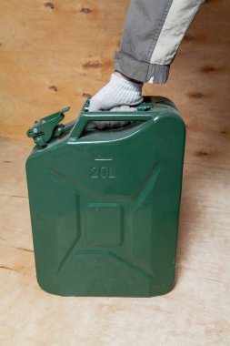 Eldivenin içinde hafif bir kontrplak grubunda yeşil metal bir teneke kutu var.