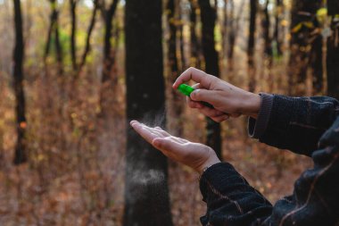 Enfeksiyonu önlemek için. Bir adamın elleri bir şişe sprey antiseptiğin kapağına basar. Kapat.