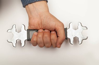 Beyaz arka grupta metrik ve ABD standartları olan sıkıca açık uçlu anahtarı tutuyor