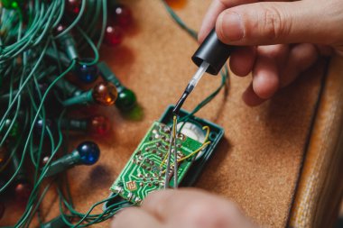 Yeni yıla hazırlanıyorduk. Köknar ağacı elektrik çelengi tamiri. Elektrikçi cımbızı ve bir bronun ellerinde.