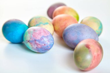 Paskalya tatiline özen göster. Farklı renklerde boyanmış birkaç tavuk yumurtası beyaz bir sırt grubunda.