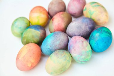 Paskalya tatiline özen göster. Farklı renklerde boyanmış birkaç tavuk yumurtası beyaz bir sırt grubunda.