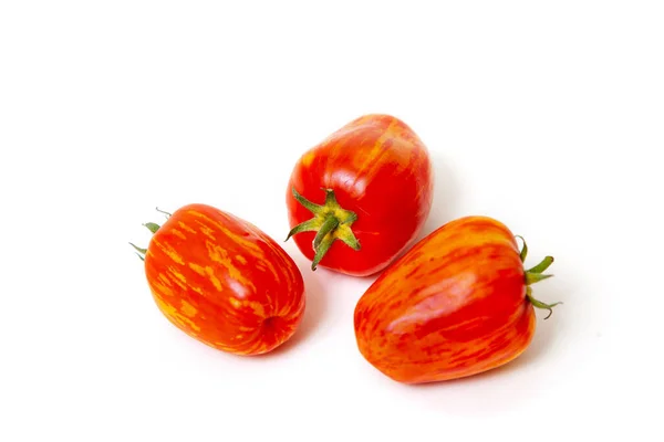 Ντομάτες Ασυνήθιστο Χρώμα Τρεις Μακριές Κόκκινες Ντομάτες Κείτονται Λευκό Πιάτο — Φωτογραφία Αρχείου