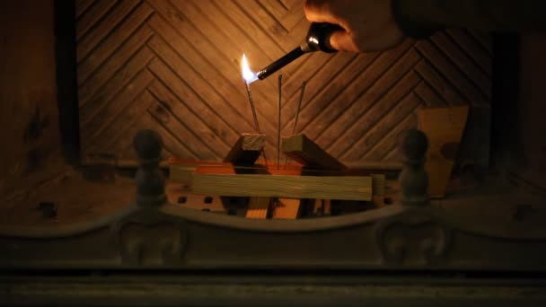 暖炉の中の輝き 手は長いライターで暖炉のベンガルのろうそくに火をつけます 左の輝きは — ストック動画