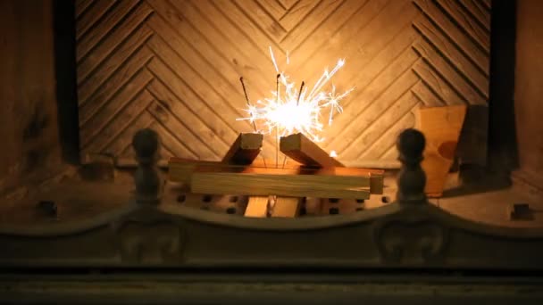 暖炉の中の輝き 暖炉の薪の間に3本のベンガルろうそくが立っている 右の燃え尽きると美しい火花を与える — ストック動画