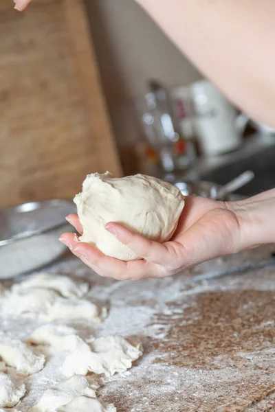 Vrouw Hand Houdt Een Stuk Deeg Door Gewicht Close Achtergrond — Stockfoto