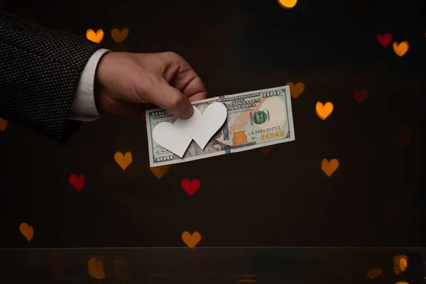 발렌타인데이 선물이에요 손에는 지폐가 위에는 심장을 누르고 어둡고 빨갛고 — 스톡 사진