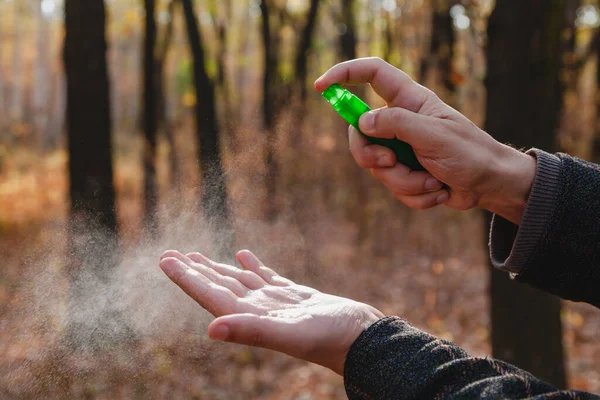 Enfeksiyonu önlemek için. Bir adamın elleri bir şişe sprey antiseptiğin kapağına basar. Kapat.