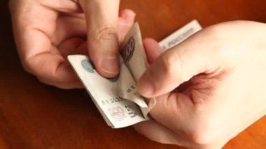 Ellerin parmakları, dolandırıcının becerikli hareketleriyle birlikte beş yüz banknot yığını Rus rublesini sayar.
