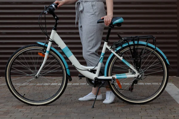 Mujer Pantalones Grises Sostiene Una Bicicleta Femenina Frente Ella Contra —  Fotos de Stock