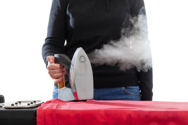 Siyah elbiseli bir kadının elinde dumanı tüten modern elektrikli ütü. Görünür buhar jeti