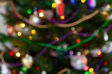 Üzerinde yazı olan bir Noel kartı için bulanık bir arkaplan. Süslemeler ve çelenklerle parıldayan Noel ağacı