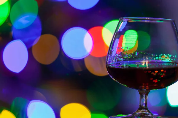 Festive Mood Elegant Glass Cognac Background Multi Colored Blurred Lights — стоковое фото
