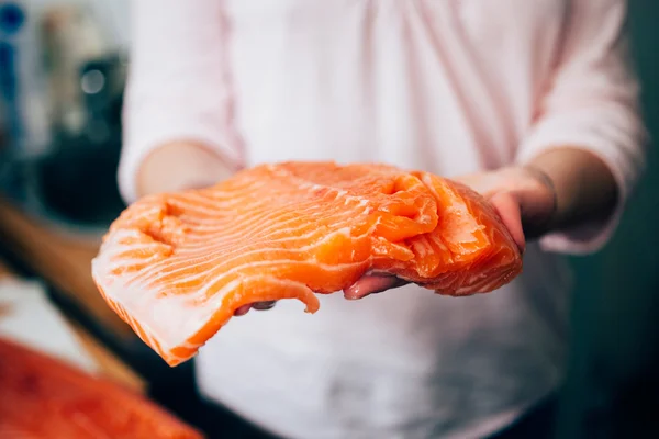 Raw salmon in woman hands