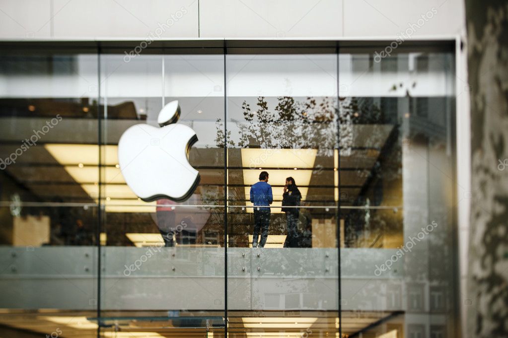 FRANKFURT AM MAIN, GERMANY - NOVEMBER 12, 2012: Apple Store logo and facade with Genius Employee explaining to a customer about the latest launched iPad Tablet.Apple is the world's largest publicly traded company which sells consumer electronics