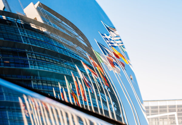 Здание Европейского парламента отражено в лобовом стекле автомобиля
