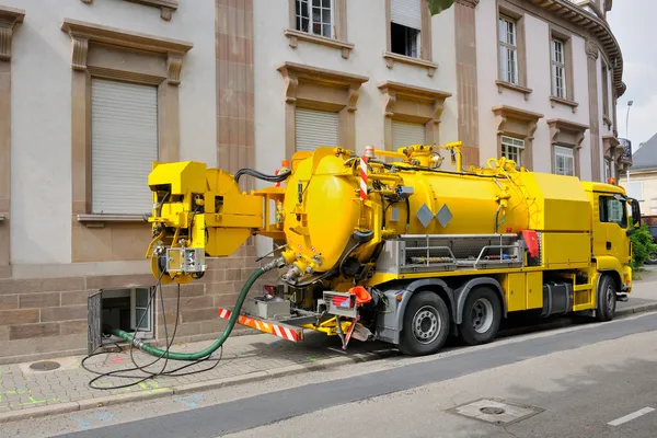 Camión de aguas residuales trabajando en el entorno urbano de la ciudad — Foto de Stock