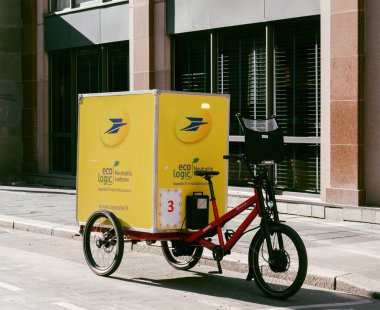 Yeni sarı La Poste posta bisikleti. Elektrikli motor ve büyük Eko Mantık.