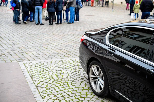 Vista lateral del coche BMW negro de lujo estacionado en la carretera empedrado pavimento — Foto de Stock