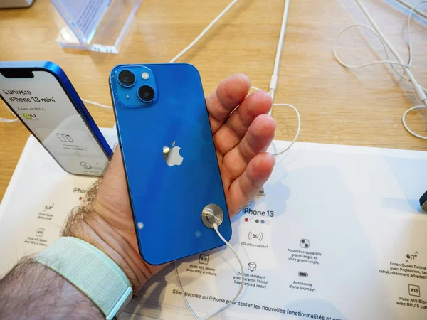 Zadní pohled na nové modré Apple Computers iPhone 13 v mužské ruce v Apple Store — Stock fotografie