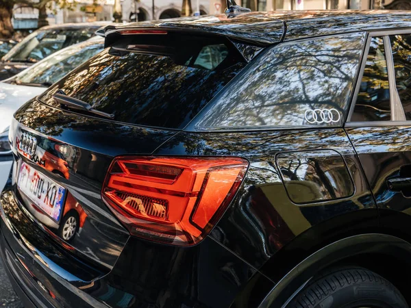 Side view of new black Audi car parked in city with four ring logotype above gas tank Stock Photo