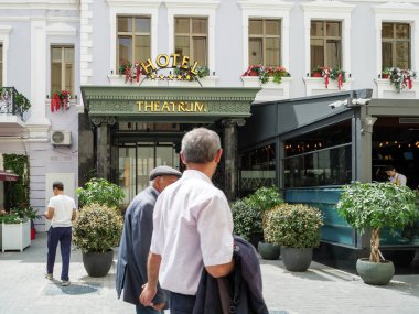 Bakü şehir merkezindeki Hotel Theatrum 'da yayalar lüks binanın önünde yürüyor.