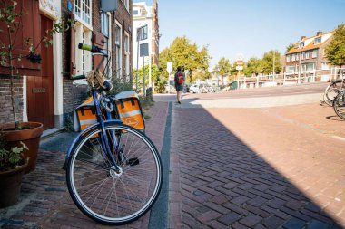 Posta arabası kaldırım taşı yolunda park etmiş bir Peugeot bisikleti.
