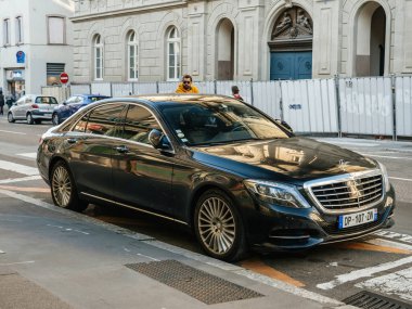 Elektrikli lüks Mercedes-Benz S600. Şehir merkezine park edilmiş, yayalar üzerinde yürüyor.