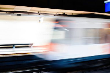İstasyon peronuna metro treni varışının odak dışı görüntüsü.