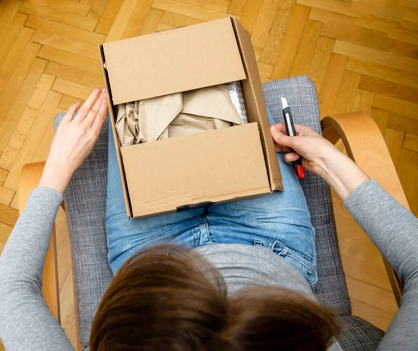 Вид сверху женщины unboxing в гостиной новая доставка электронной коммерции заказанных товаров — стоковое фото