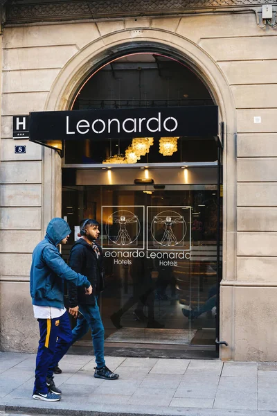 Barselona caddesinde kapüşonlu ve kulaklıklı genç kız Leonardo Oteli 'nin önünde yürüyor. — Stok fotoğraf