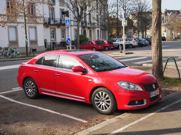 Vista lateral del coche Suzuki rojo estacionado en la calle en la ciudad francesa — Foto de Stock