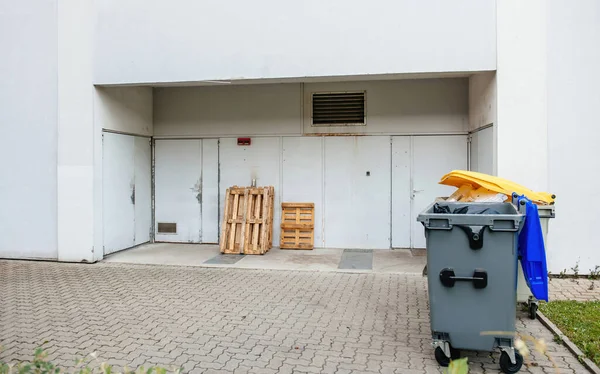 Contenedor de residuos de plástico y paletas de madera en la puerta trasera de un gran supermercado —  Fotos de Stock