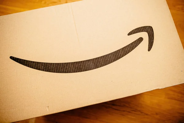 Amazon prime cardboard box parcel on the wooden floor — Stock Photo, Image