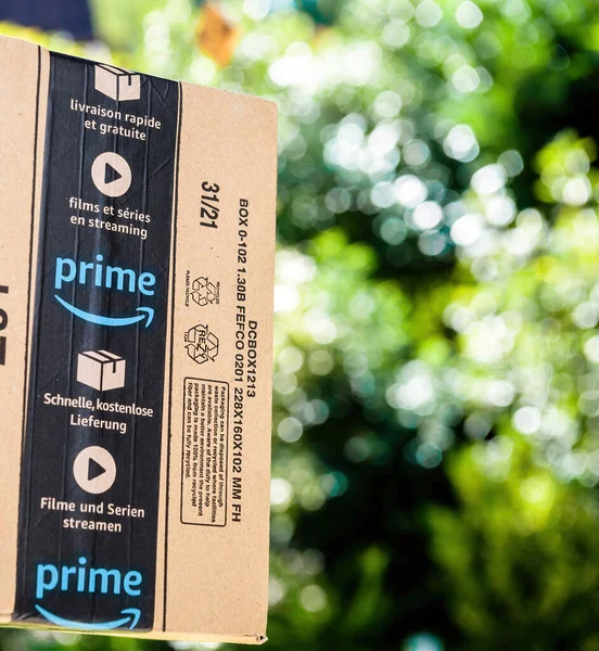 Nuevo paquete de cartón Amazon Prime con el logotipo de la flecha sonriente en la protección escocesa — Foto de Stock