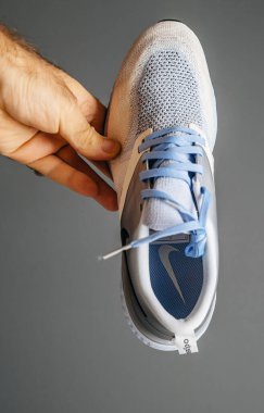 Pov erkek eli yeni koşu ayakkabıları tutuyor Nike logotype tabanında