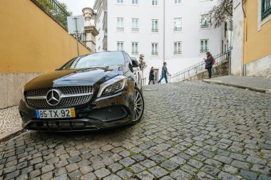 Lüks Mercedes-Benz Coupe arabası Lizbon şehir merkezindeki kaldırım taşı yolda park halinde.