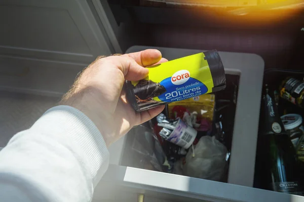 Pov vista de la mano masculina sosteniendo por encima de la papelera de cocina nuevo paquete de bolsas de plástico de desecho de cora —  Fotos de Stock