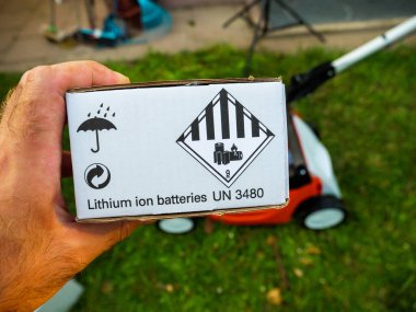 Unboxing of new lithium ion batteries with UN 380 sticker sign for Stihl lawn mower clipart